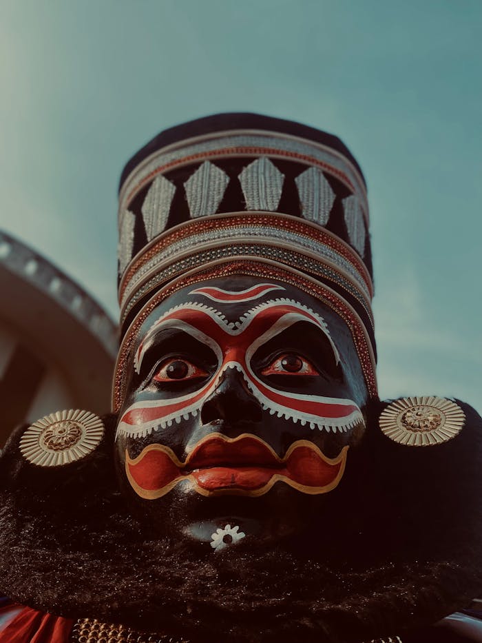 Close-up of a traditional Kathakali dancer in full costume with a detailed headdress and face paint.